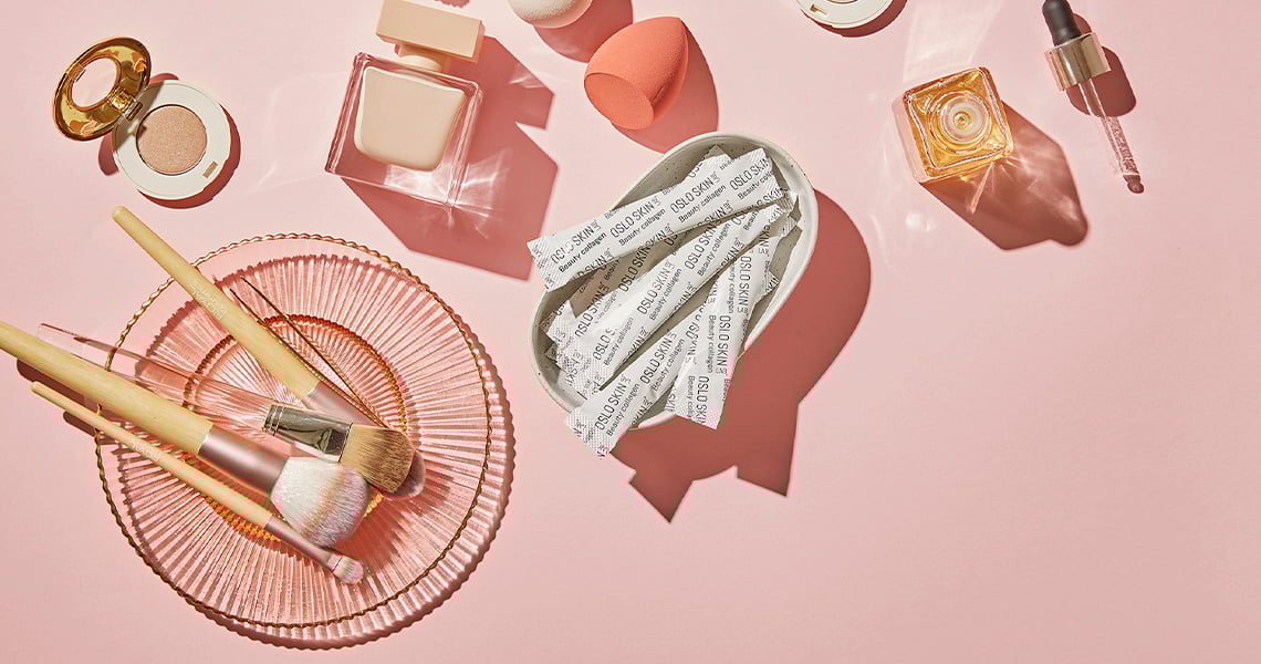 Smink och kollagenpulver från Oslo Skin Lab mot en rosa bakgrund