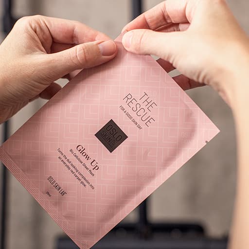 Händer öppnar lyxiga ansiktsmasken Glow Up från Oslo Skin Lab